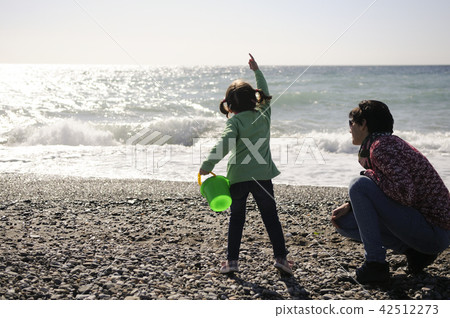 Mother and little girl having fun on the beach in winter 42512273