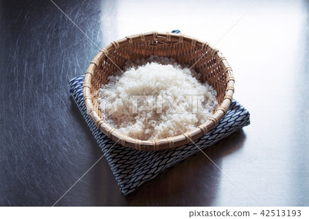 在不銹鋼櫃檯上方洗淨進入竹子米飯的米飯 在不銹鋼櫃檯上方洗淨進入竹子米飯的米飯 42513193
