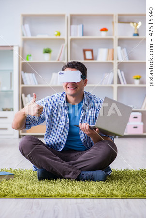 Freelance student with virtual reality glasses at home Freelance student with virtual reality glasses at home 42515340