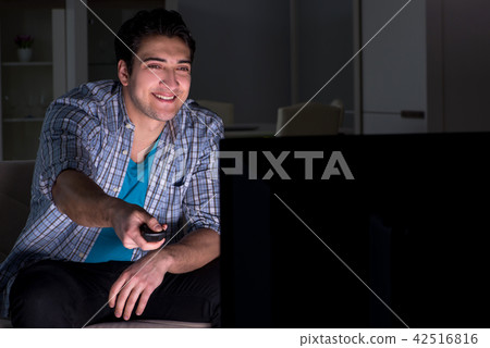 Young man watching tv late at night 42516816