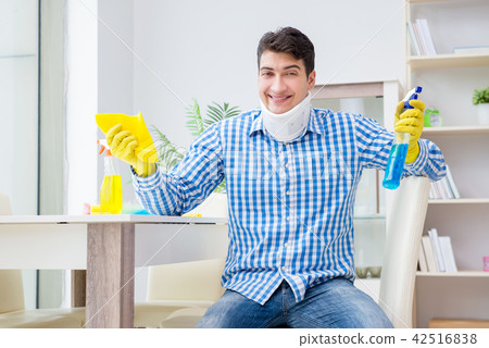 Man with neck unjury cleaning house in housekeeping concept Man with neck unjury cleaning house in housekeeping concept 42516838