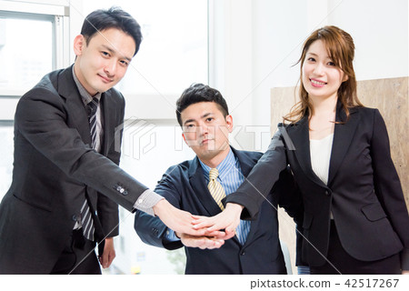 Three business people who keep hand in hand at the center 42517267