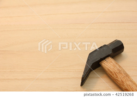The hammer placed on the wooden board. The hammer placed on the wooden board. 42519268