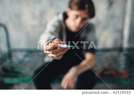 Male junkie reaching out hand with syringe Male junkie reaching out hand with syringe 42519583
