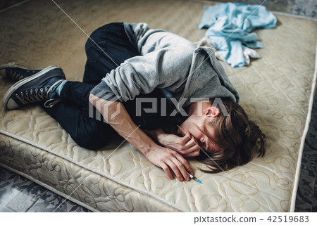 Male drug addict sleeping in bed after dose 42519683