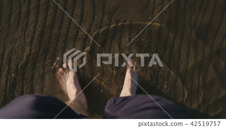 pov view man walking barefoot in shallow water on beach pov view man walking barefoot in shallow water on beach 42519757