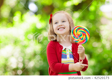 Little girl with colorful candy lollipop 42520173