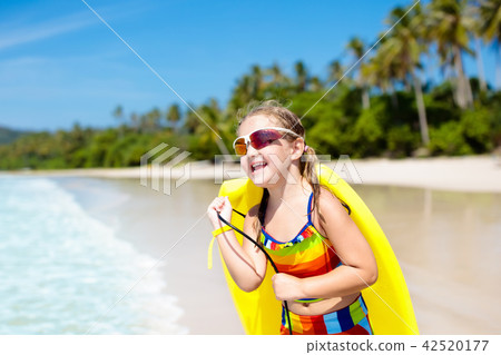 Child surfing on tropical beach. Surfer in ocean. Child surfing on tropical beach. Surfer in ocean. 42520177