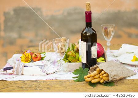 Lunch in the garden with wine and fruit. Romantic dinner in the open air. Autumn leaves of flowers. 42520450