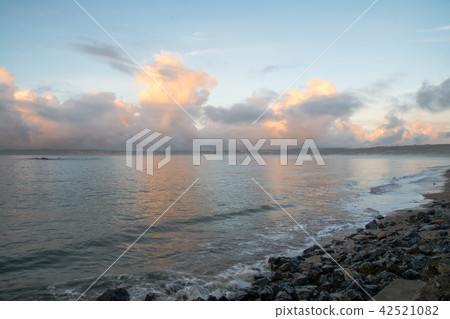 Coast with clouds, sand and rock mixed with sunrise lit by the morning At the coast of Cornwall, England 42521082