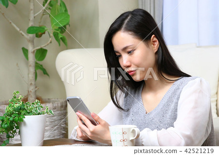 A woman who plays a smartphone A woman who plays a smartphone 42521219