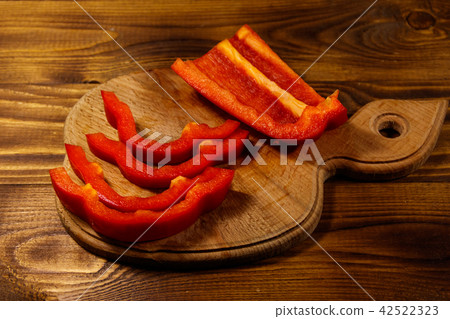 Fresh red pepper on cutting board on wooden table 42522323