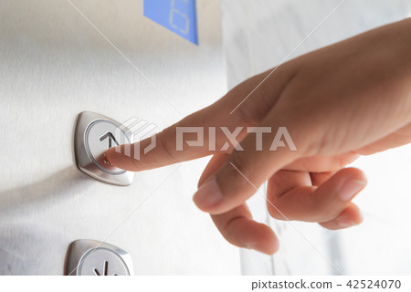 Close up woman hand press a up button of elevator 42524070