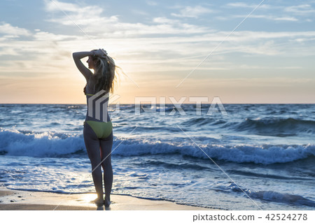 Woman by the sea at dawn Woman by the sea at dawn 42524278