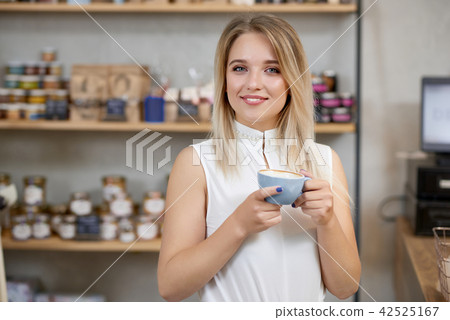 Portrait of smiling girl keeping cup of coffee , looking at camera. Portrait of smiling girl keeping cup of coffee , looking at camera. 42525167