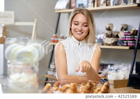 Cute girl with blonde hair buying croissants in local shop. Cute girl with blonde hair buying croissants in local shop. 42525169
