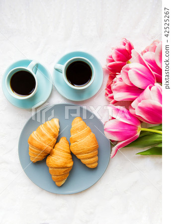 two cups of coffee, croissants and a bouquet of pink tulips, beautiful morning 42525267