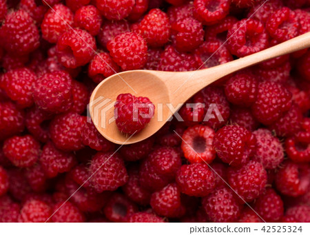 Fresh raspberries and a wooden spoon 42525324