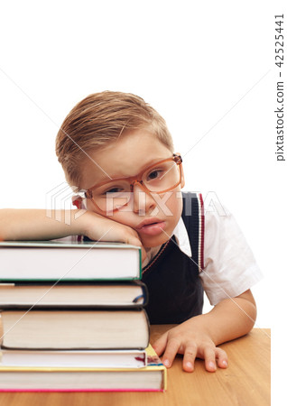 Funny cute little boy posing at school desk Funny cute little boy posing at school desk 42525441