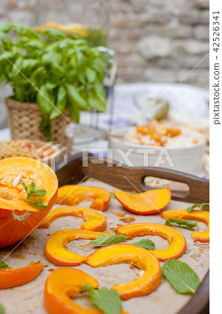 Lunch at home outdoors in the courtyard. Autumn vegetables and fruits. Baked pumpkin with honey and Lunch at home outdoors in the courtyard. Autumn vegetables and fruits. Baked pumpkin with honey and 42526341