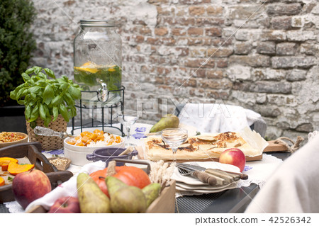 Lunch at home outdoors in the courtyard. Autumn vegetables and fruits. Family picnic. Copy space Lunch at home outdoors in the courtyard. Autumn vegetables and fruits. Family picnic. Copy space 42526342