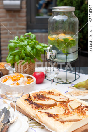 Lunch at home outdoors in the courtyard. Autumn vegetables and fruits. Pie with pear and spices, Lunch at home outdoors in the courtyard. Autumn vegetables and fruits. Pie with pear and spices, 42526343