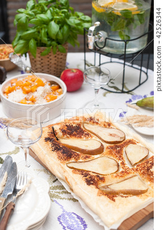 Lunch at home outdoors in the courtyard. Autumn vegetables and fruits. Pie with pear and spices, Lunch at home outdoors in the courtyard. Autumn vegetables and fruits. Pie with pear and spices, 42526344