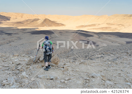 Hiking tourist in desert trek adventure Hiking tourist in desert trek adventure 42526374
