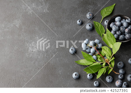 Fresh blueberries branch on black stone background Fresh blueberries branch on black stone background 42527391