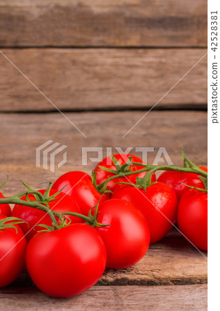 Red tomatoes on a branch on the table. 42528381