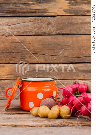 Enamelware Cup and vegetables still life. 42528745