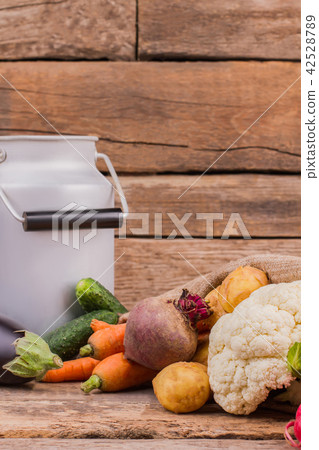 Different vegetables and enamelware milk churn. 42528789