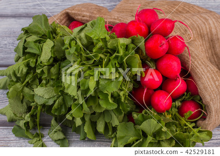 Raw radishes with green leaves. 42529181