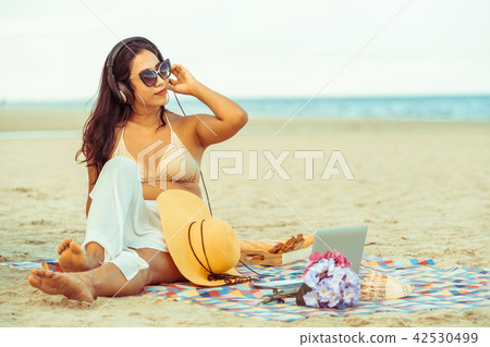 Plus size young woman sitting on the beach. 42530499