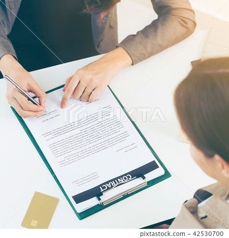 Businesswoman signs agreement contract in office. Businesswoman signs agreement contract in office. 42530700