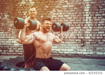 Two muscular athletes training 42535333
