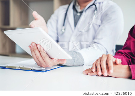 Doctor consulting with patient presenting results Doctor consulting with patient presenting results 42536010