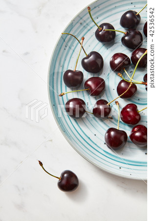 Sweet berries red ripe on blue plate on gray background with place for text. Flat lay. Sweet berries red ripe on blue plate on gray background with place for text. Flat lay. 42536542