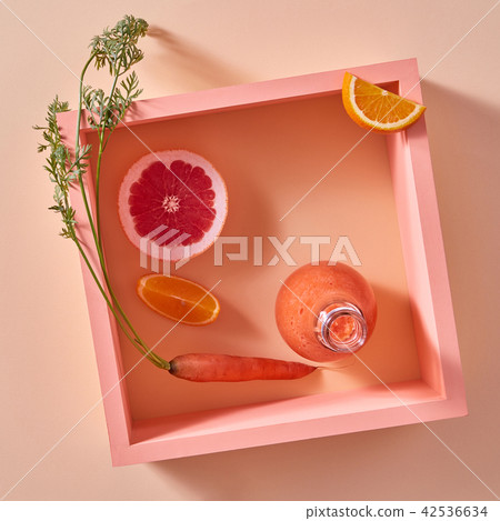 Orange detox smoothies from vegetables and fruits in a glass bottle on a yellow paper background. Orange detox smoothies from vegetables and fruits in a glass bottle on a yellow paper background. 42536634