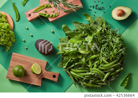 Gren vegetables for salad - lettuce, greens, pea sticks, rosemary, avocado, lime on a wooden cutting 42536664