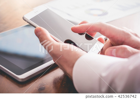Businessman Analyzing Statistics With Smartphone 42536742