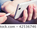 Headphone Jack Of White Smartphone Gets Plugged In 42536746