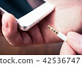 Headphone Jack Of White Mobile Gets Plugged In 42536747