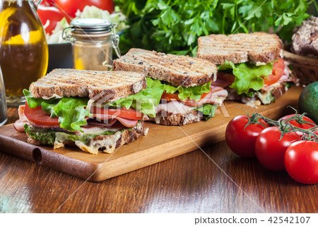 Sandwiches with ham, cheese, tomatoes and cucumber Sandwiches with ham, cheese, tomatoes and cucumber 42542107