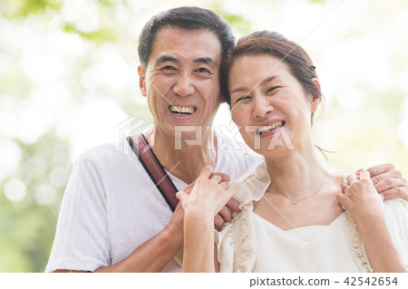 Japanese middle-class couple traveling in summer resort Japanese middle-class couple traveling in summer resort 42542654