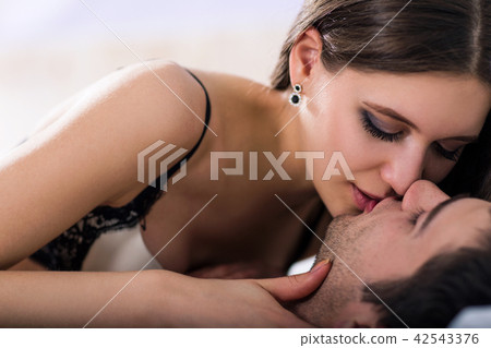 Sexy young couple kissing and playing in