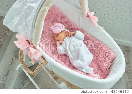 Cute newborn baby girl with hand in mouth. 42546313