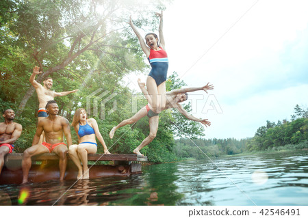 Enjoying river party with friends. Group of beautiful happy young people at the river together 42546491