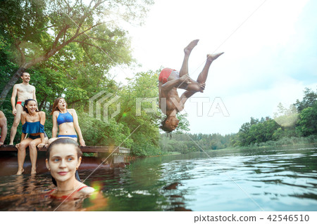 Enjoying river party with friends. Group of beautiful happy young people at the river together Enjoying river party with friends. Group of beautiful happy young people at the river together 42546510