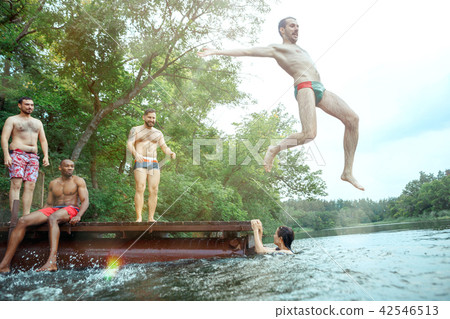 Enjoying river party with friends. Group of beautiful happy young people at the river together 42546513